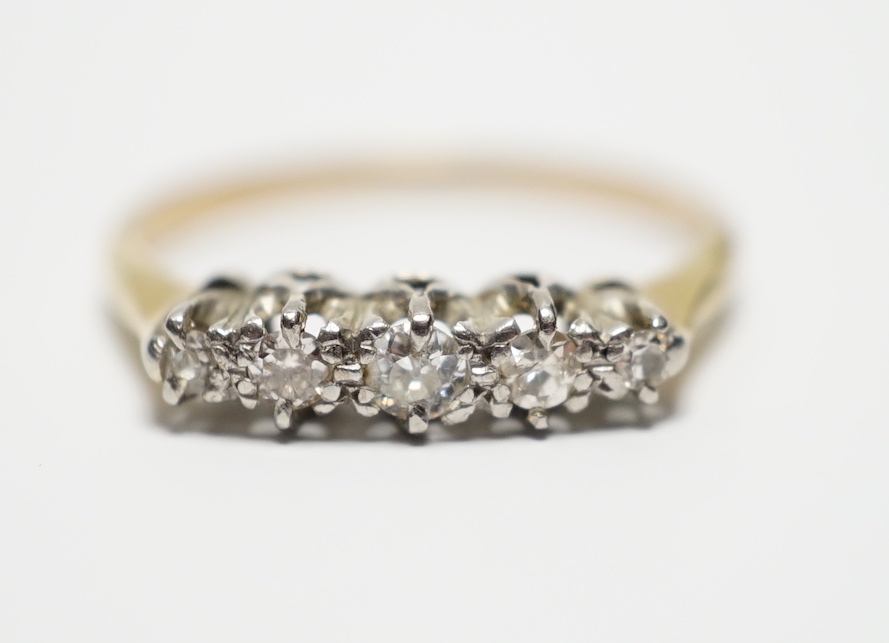 A yellow metal and graduated five stone diamond set half hoop ring, size M, gross weight 2 grams.